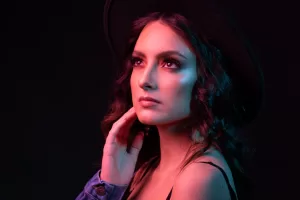 Elegant woman in a hat under colorful lighting